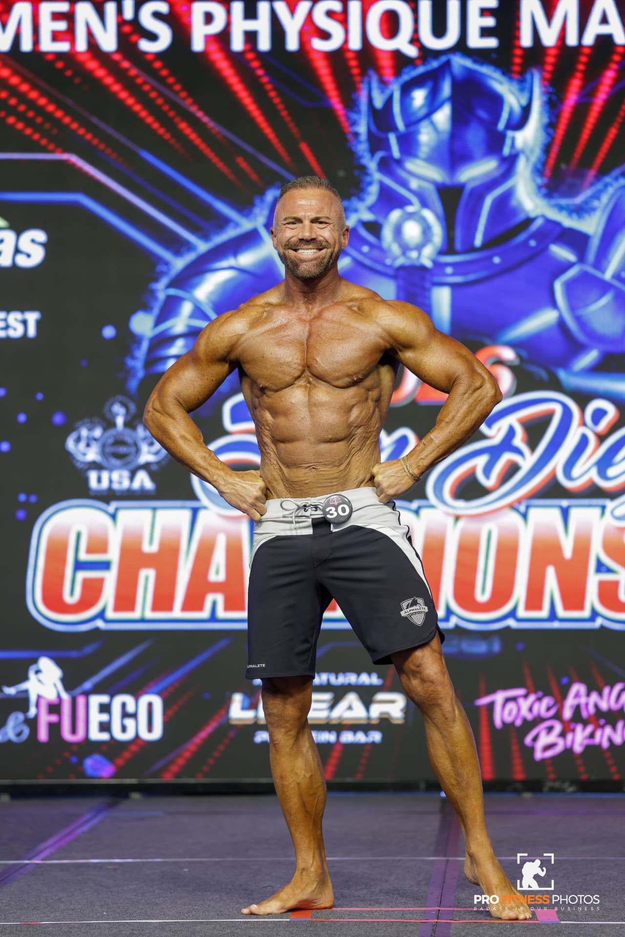 Tyler Stanley on stage at a men's physique bodybuilding competition
